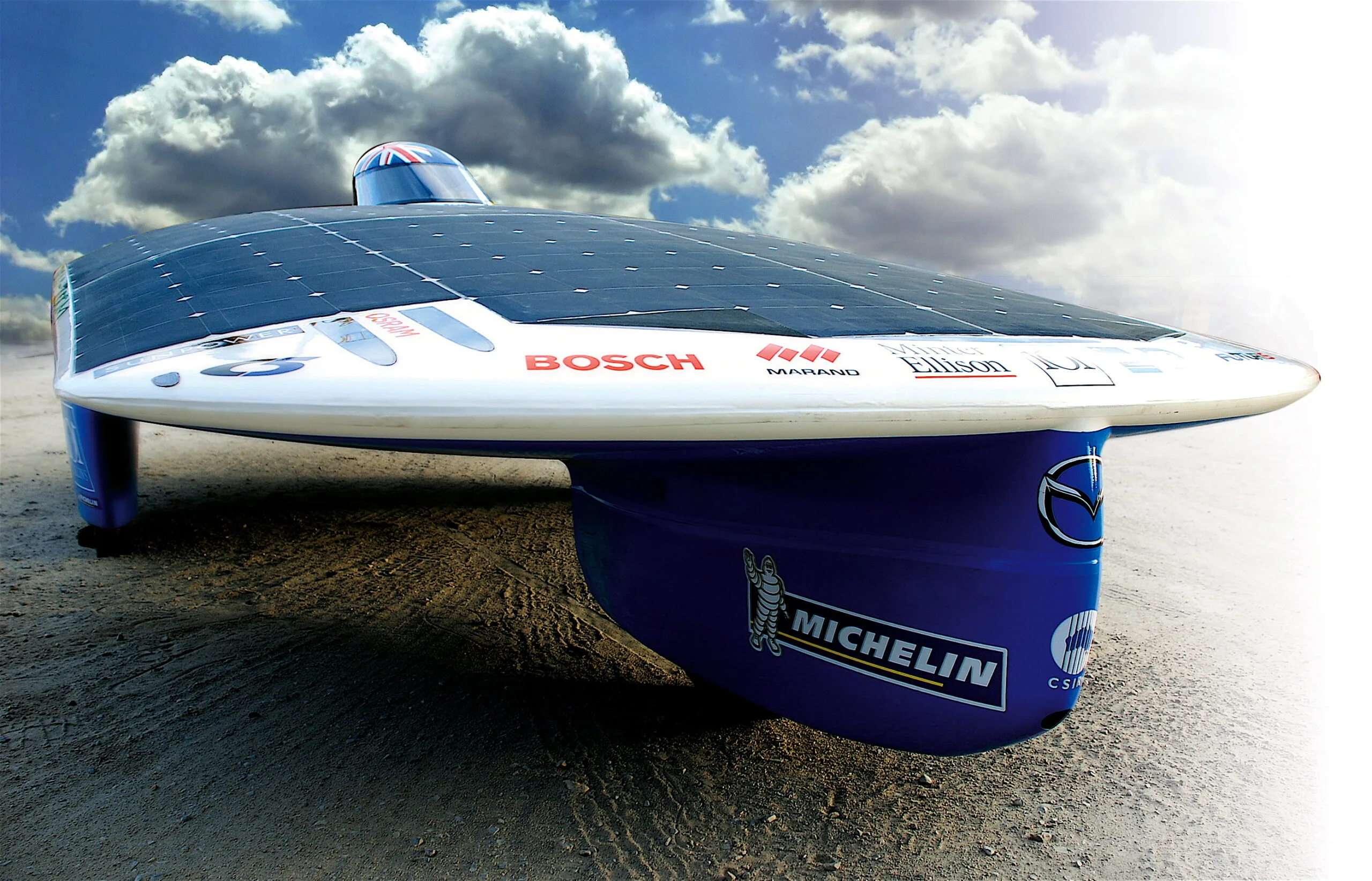 The flat, wide Aurora 101 solar car with its solar array and small canopy, front view