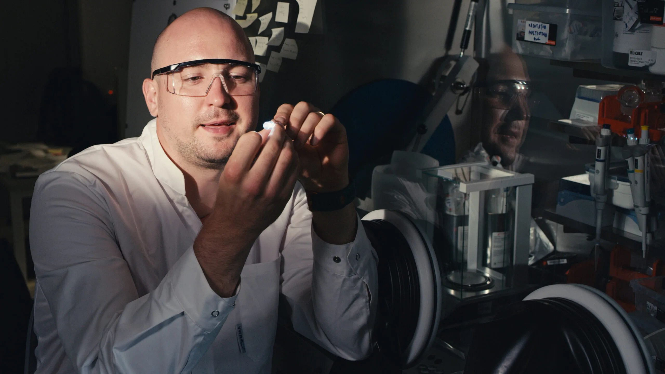 Researcher holding a working sodium-ion battery in a laboratory