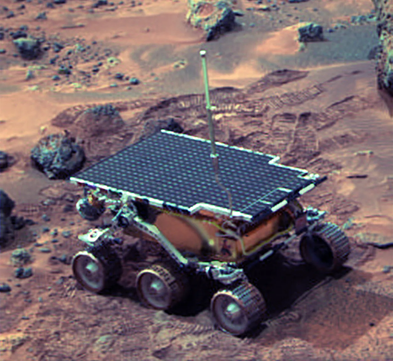 The small six-wheeled Sojourner rover with its flat solar panel next to a rock on Mars