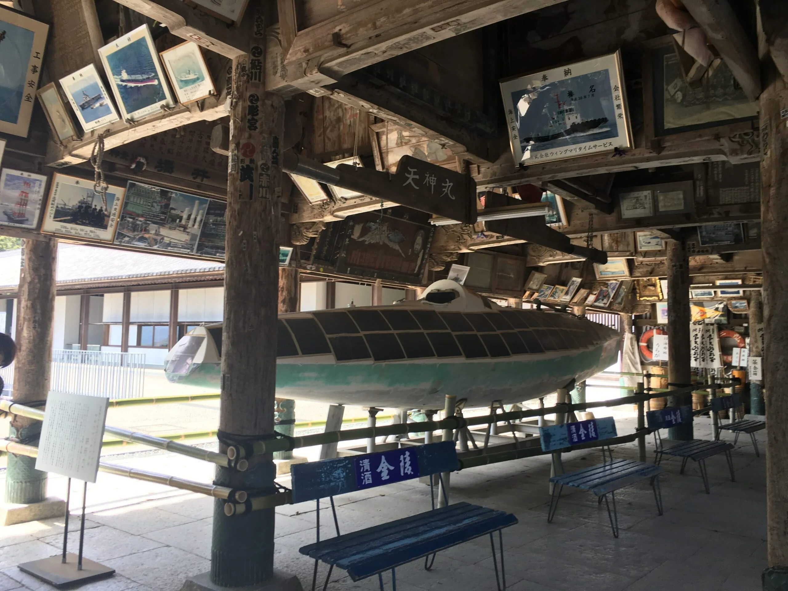 The slim solar boat Malt's Mermaid, its deck covered in solar panels, displayed at Kotohira-gu shrine in Japan