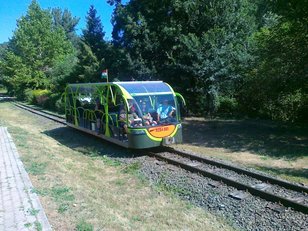 The open green solar-powered railcar on the narrow-gauge Királyrét forest railway in Hungary