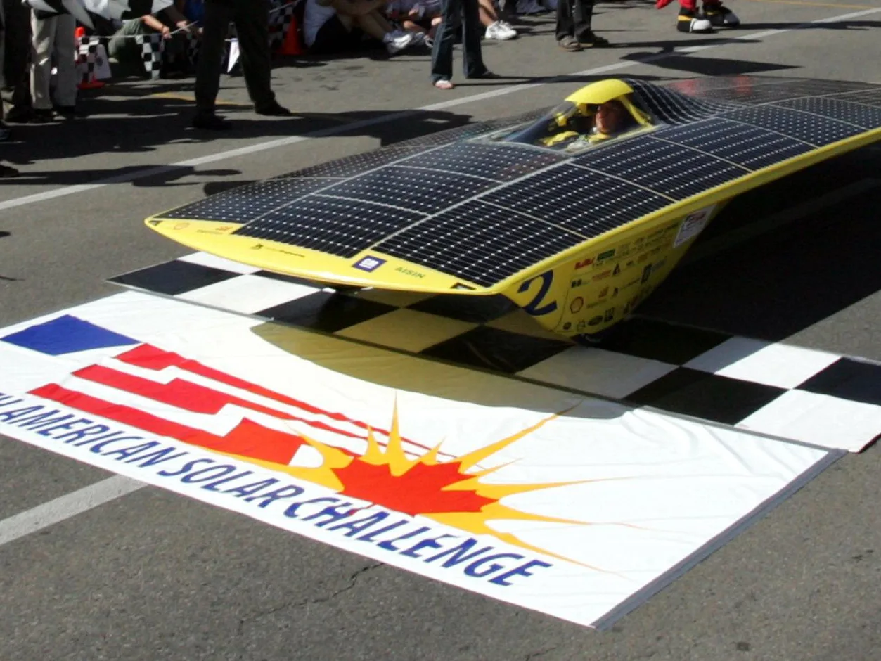 The yellow Michigan solar car Momentum crossing the finish line of the 2005 North American Solar Challenge in Calgary