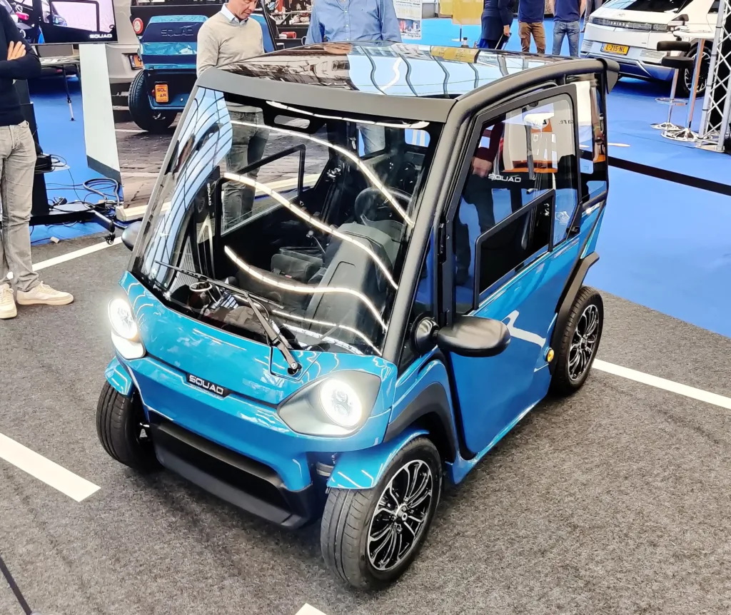 Front view of the small two-seat Squad Solar City Car with its solar roof, at Fully Charged 2022