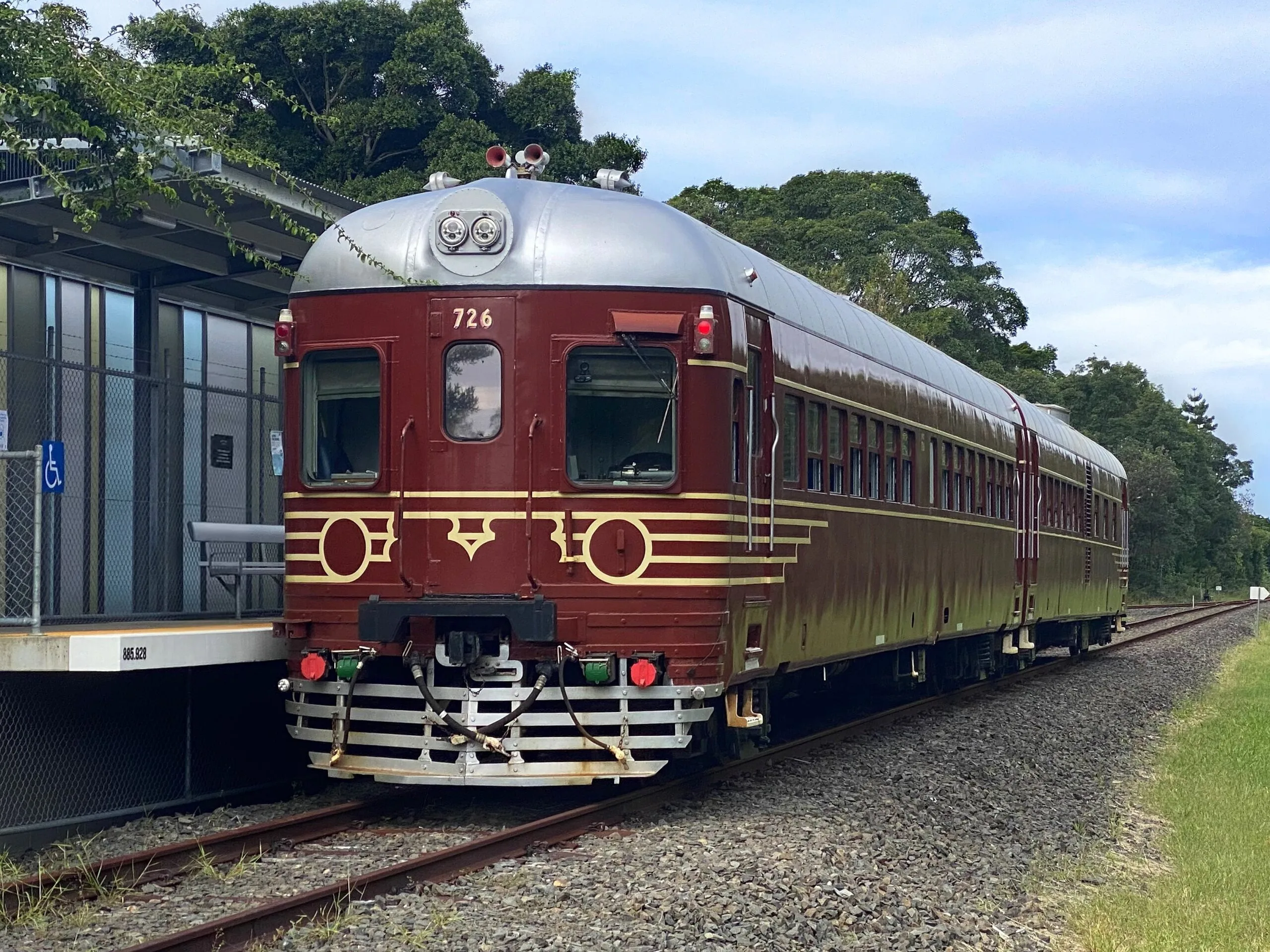 The vintage red Byron Bay solar train standing at the platform in Byron Bay, Australia