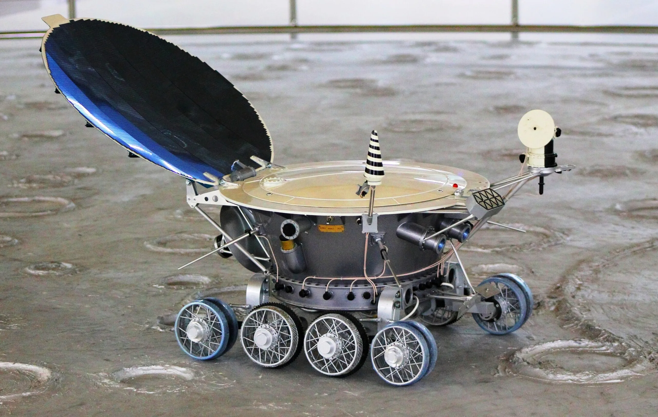 Model of the Soviet Lunokhod moon rover with its open solar lid and eight wheels