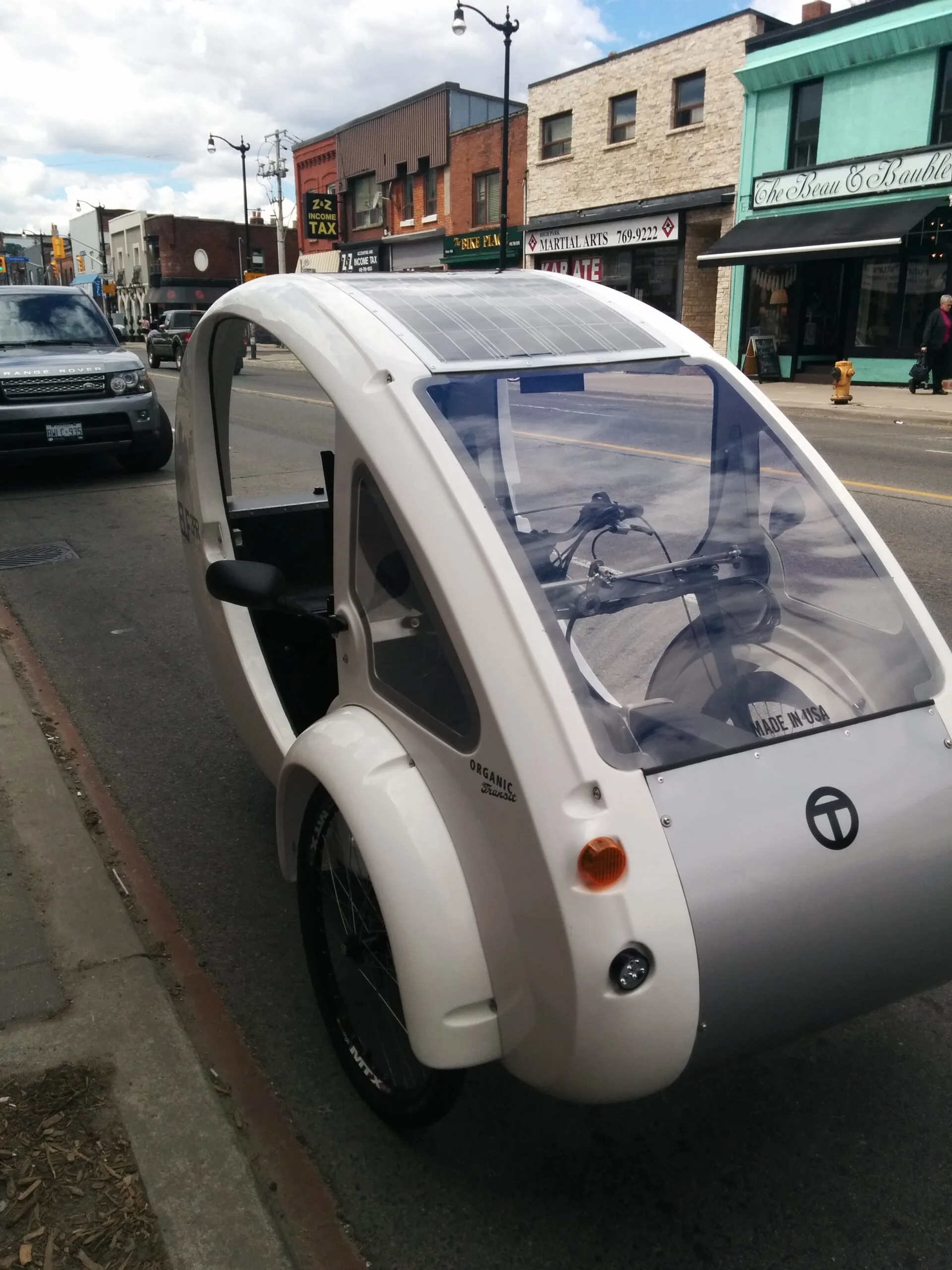 Organic Transit ELF solar and pedal-powered velomobile parked on a street in Toronto