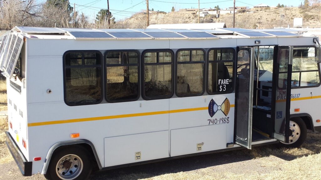 The white Solar Buzz shuttle bus with homemade solar panels on its roof in Truth or Consequences, New Mexico